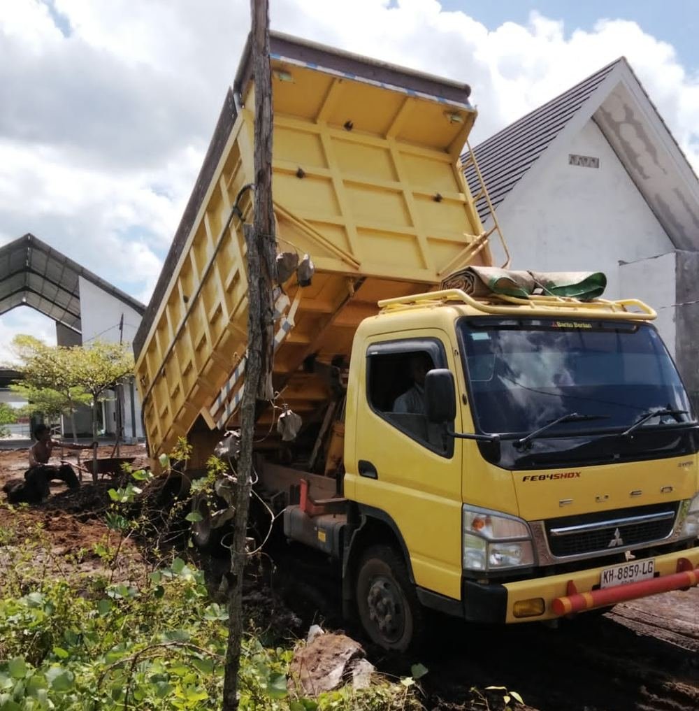 Dump truck membongkar tanah urug